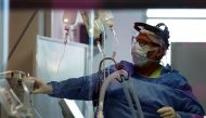 Nurse David Rosas checks a patient suffering from the coronavirus disease (COVID-19) in an intensive care unit of a hospital, on the outskirts of Buenos Aires, Argentina October 16, 2020. Picture taken October 16, 2020. REUTERS/Agustin Marcarian
