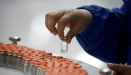 FILE PHOTO: A worker performs a quality check in the packaging facility of Chinese vaccine maker sinovac Biotech, developing an experimental coronavirus disease (COVID-19) vaccine, during a government-organized media tour in Beijing, China, September 24, 