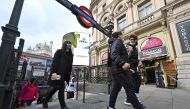 People wearing face masks or coverings due to the COVID-19 pandemic, react as they exit an Underground station in London on October 20, 2020. AFP / JUSTIN TALLIS