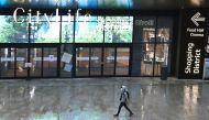 A person wearing a face mask walks at a shopping mall ahead of weekend closure of shopping centres, a measure imposed by the Lombardy region to curb the coronavirus disease (COVID-19) infections, in Milan, Italy, October 23, 2020. REUTERS/Flavio Lo Scalzo