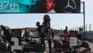 Mercedes' British driver Lewis Hamilton (C) gets-off his car after taking the pole position after the qualifying session at the Autodromo Internacional do Algarve on October 24, 2020 in Portimao ahead of the Portuguese Formula One Grand Prix. / AFP /JOSE 