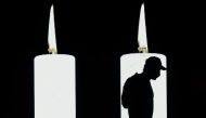 In this file photo taken on August 06, 2020 A man walks in front of a screen projecting candles in tribute to the dead by COVID-19 during the 482th anniversary of the city of Bogota. Colombia's Ministry of Health reported that the country surpassed on Oct
