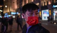 A man wearing a face mask as a preventive measure against the Covid-19 coronavirus walks along a pedestrian street in Shanghai on October 23, 2020. / AFP / Hector RETAMAL