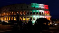 FILE PHOTO: People sit in front of Rome's ancient Colosseum illuminated with colours of the Italian flag in Rome, Italy, May 31, 2020. REUTERS/Remo Casilli/File Photo
