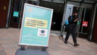 A woman wearing a protective mask walks near an informational poster, amid the coronavirus disease (COVID-19) outbreak, in Warrington, Britain September 22, 2020. REUTERS/Molly Darlington/File Photo