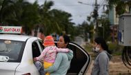 Residents get in a car after leaving their homes to move to evacuation centres in central Vietnam's Quang Nam province on October 27, 2020, ahead of Typhoon Molave's expected landfall. / AFP / MANAN VATSYAYANA