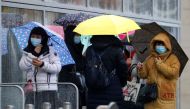 People wearing face masks shelter under umbrellas outside a department store following the outbreak of the coronavirus disease (COVID-19) in Manchester, Britain, October 26, 2020. REUTERS/Phil Noble/File Photo