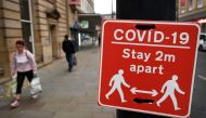 Shoppers walk past a sign displaying Covid-19 guidelines, in Bradford, west Yorkshire on October 31, 2020, as the number of cases of the novel coronavirus COVID-19 rises. AFP / Paul Ellis