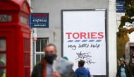 People walk past a poster by artist Hayden Kay, amid the coronavirus (COVID-19) outbreak, in London, Britain, October 30, 2020. REUTERS/Henry Nicholls