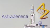 A test tube labeled with the vaccine is seen in front of AstraZeneca logo in this illustration taken, September 9, 2020. REUTERS/Dado Ruvic//File Photo