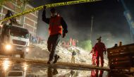 Rescue workers search for survivors in the debris of a collapsed building on November 1, 2020 in the Bayrakli district of Izmir, after a powerful earthquake struck Turkey's western coast and parts of Greece. Rescue workers were searching eight buildings i