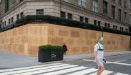 A person walks by a boarded-up Saks Fifth Avenue on November 1, 2020, in New York City. Businesses have taken to boarding up storefronts in anticipation of unrest related to the presidential election. David Dee Delgado/Getty Images/AFP 