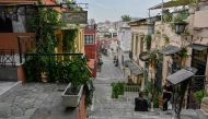 People talk while standing by empty terraces in Plaka district of central Athens as cafes bars and restaurants close due to a partial lockdown to stem the spread of the novel coronavirus, Covid-19, on November 3, 2020. / AFP / LOUISA GOULIAMAKI