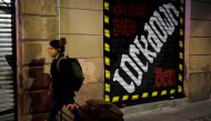 A woman wearing a face mask pushes her suitcase on a street, after Catalonia's government imposed new restrictions in an effort to control the spread of the coronavirus disease (COVID-19), in Barcelona, Spain October 29, 2020. REUTERS/Nacho Doce
