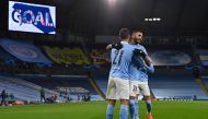 Manchester City's Spanish midfielder Ferran Torres (L) celebrates scoring the opening goal with Manchester City's Algerian midfielder Riyad Mahrez during the UEFA Champions League football Group C match between Manchester City and Olympiakos at the Etihad