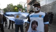 Supporters of Argentine former football star and coach of Gimnasia y Esgrima La Plata Diego Maradona gather outside the hospital where he will undergo brain surgery for a blood clot, in Olivos, Buenos Aires province, on November 3, 2020. / AFP / JUAN MABR
