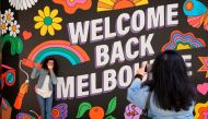 FILE PHOTO: People take photos in front of a 'Welcome Back' sign in Melbourne after coronavirus disease (COVID-19) restrictions were eased for the state of Victoria, Australia, October 28, 2020. REUTERS/Sandra Sanders/File Photo
