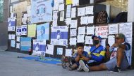 Fans of Argentine soccer great Diego Maradona sit next to a wall filled with encouraging messages outside the clinic where Maradona underwent brain surgery, in Olivos, on the outskirts of Buenos Aires, Argentina November 5, 2020. REUTERS/Matias Baglietto