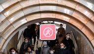 People wearing face masks to protect against the coronavirus disease walk down stairs at a metro station in Moscow on November 6, 2020. Russia confirmed new record of daily new Covid-19 cases (20,582) on November 6. / AFP / Kirill KUDRYAVTSEV