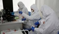 FILE PHOTO: People wearing protective coverall work at the drive-thru testing centre on the coronavirus disease (COVID-19) in Warsaw, Poland, October 2, 2020. REUTERS/Kacper Pempel