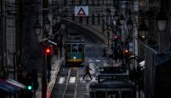 A man wearing a face mask crosses a street in downtown Lisbon on November 7, 2020. / AFP / PATRICIA DE MELO MOREIRA
