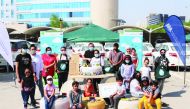 Officials from AAB and community members with upcycled items during an event to mark QSW.