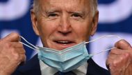 In this file photo former Democratic Presidential candidate Joe Biden removes his facemask as he arrives to speak at the Chase Center in Wilmington, Delaware, on November 4, 2020. / AFP / JIM WATSON