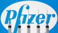 Syringes are seen in front of a displayed pfizer logo in this illustration taken, November 10, 2020. REUTERS/Dado Ruvic/Illustration
