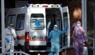 Medical workers wearing personal protective equipment (PPE) are seen next to an ambulance outside the Cotugno hospital as the battle with the coronavirus disease (COVID-19) intensifies, in Naples, Italy, November 9, 2020. REUTERS/Ciro De Luca
