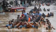 Rescuers pull a rubber boat carrying residents through a flooded street after Typhoon Vamco hit in Marikina City, suburban Manila on November 12, 2020. / AFP / Ted ALJIBE