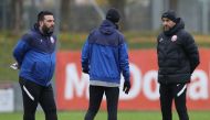 Qatar coach Felix Sanchez (right) and his assistants are all wrapped up in team trainers and jackets in Vienna, Austria, yesterday.  