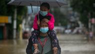 A man carries a child on his shoulders as he wades through a flooded road following Typhoon Vamco, in Marikina, Metro Manila, Philippines, November 12, 2020. REUTERS/Eloisa Lopez
