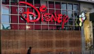In this file photo taken on June 01, 2020 a man walks past a boarded up Disney store in Times Square shorty before the 11 p.m. curfew went into effect, as demonstrators rallied across the five boroughs Demonstrations are being held across the US after Geo