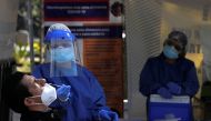 A healthcare worker wearing personal protective equipment (PPE) takes a swab sample from a man to be tested for the coronavirus disease (COVID-19) in Mexico City, Mexico November 13, 2020. Picture taken November 13, 2020. REUTERS/Carlos Jasso