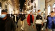 People wearing protective masks walk along the principal shopping street of Via del Corso, as the number of people infected by the coronavirus disease (COVID-19) continues to rise, in Rome, Italy, November 14, 2020. REUTERS/Remo Casilli
