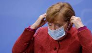 German Chancellor Angela Merkel puts on her face mask before leaving after a news conference on the coronavirus following video consultations with the premiers of Germany's 16 federal states at Chancellery in Berlin on November 16, 2020. / AFP / POOL / Od