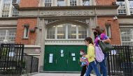 (FILES) In this file photo students walk past a public school on October 5, 2020 in the Brooklyn Borough of New York City. New York's public schools will close temporarily to combat a rise in coronavirus cases, its mayor announced on November 18, 2020, de