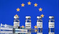 An illustration picture shows vials with Covid-19 Vaccine stickers attached, and syringes, with a flag of the European Union, on November 17, 2020. / AFP / JUSTIN TALLIS
