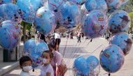 Children wearing face masks stand near balloons at Hong Kong Disneyland Resort following the coronavirus disease (COVID-19) outbreak in Hong Kong, China November 20, 2020. REUTERS/Lam Yik
