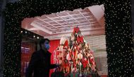 A pedestrian wearing a face mask or covering due to the COVID-19 pandemic, walk past Christmas-themed window display at Selfridges department store in central London on November 17, 2020. Britain has been the worst-hit nation in Europe recording more than
