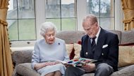 Britain's Queen Elizabeth and Prince Philip, Duke of Edinburgh look at their homemade wedding anniversary card, given to them by their great grandchildren Prince George, Princess Charlotte and Prince Louis, ahead of their 73rd wedding anniversary, in the 