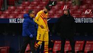Barcelona's Spanish defender Gerard Pique (C) walks off the pitch after getting injured during the Spanish League football match between Club Atletico de Madrid and FC Barcelona at the Wanda Metropolitano stadium in Madrid on November 21, 2020. / AFP / GA