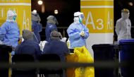 This photo taken on November 22, 2020 shows health workers in protective suits waiting to conduct COVID-19 coronavirus tests on staff at Pudong Airport in Shanghai. China OUT / AFP / CNS / STR
