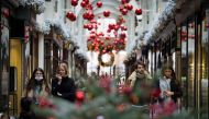 Pedestrians wearing face masks due to the COVID-19 pandemic, walk past Christmas-themed window displays inside Burlington Arcade in central London, on November 23, 2020. Prime Minister Boris Johnson's latest plan is to roll out mass testing to the hardest
