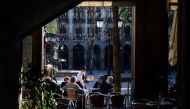 A waiter serves customers at a restaurant in Barcelona on November 23, 2020 as bars, restaurants and movie theatres were allowed to reopen in Spain's northeastern region of Catalonia after being closed for over a month as part of measures to slow coronavi