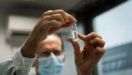 A laboratory assistant holds a tube with Russia's 
