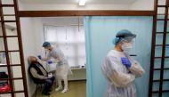 David Antos, 23, a medical student, wearing protective equipment collects a swab sample from a person at a coronavirus disease (COVID-19) testing center in Prague, Czech Republic, October 30, 2020. REUTERS/David W Cerny/File Photo