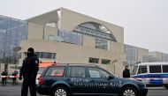Policemen guard a car with the lettering 'Stop globalisation politics' painted on its doors after it drove into the gate of the German Chancellery and was removed by police, in central Berlin on November 25, 2020. German police said on November 25 they ha