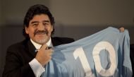 (FILES) In this file photo taken on February 26, 2013 Football legend Argentinian Diego Maradona holds a SSC Napoli number 10 jersey during a press conference in Naples. Argentinian football legend Diego Maradona passed away on November 25, 2020. / AFP / 