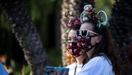 Cheryl Ooley and Stephanie Horning wait to get inside Disney California Adventure as its retail stores and restaurants partially reopened without rides during the outbreak of the coronavirus disease (COVID-19), in Anaheim, California, U.S., November 19, 2
